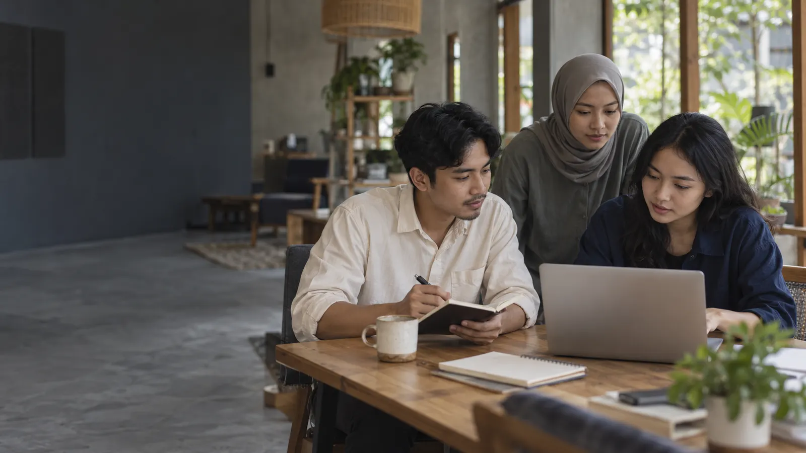 Illustrative scene of Indonesian colleagues reviewing a project together